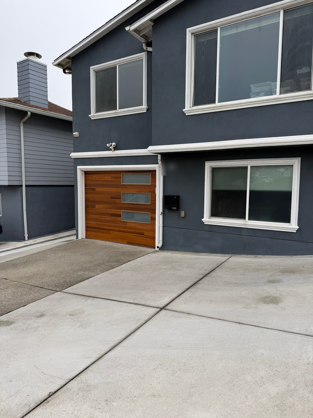 Wood-look sectional garage door on a stucco house